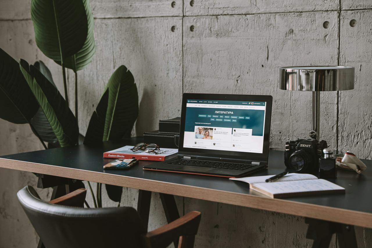 a laptop computer sitting on top of a wooden desk